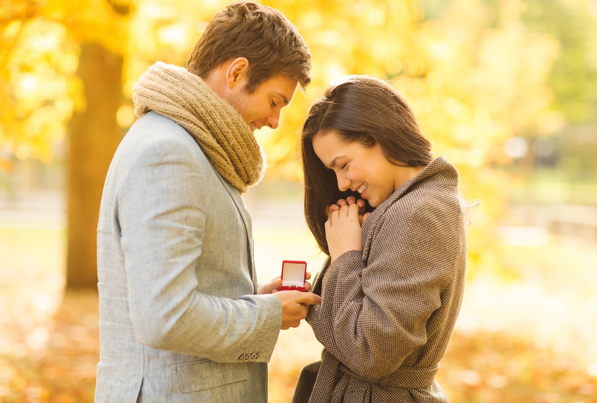 engagement ring, love proposal, holidays, love, couple, relationship and dating concept - romantic man proposing to a woman in the autumn park